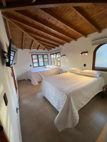 a bedroom with two beds and a large window at Habitación con baño privado en casa de campo ubicada en Santa Elena in Santa Elena