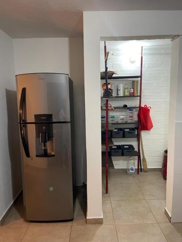 a kitchen with a stainless steel refrigerator in a room at Habitación con baño privado en casa de campo ubicada en Santa Elena in Santa Elena