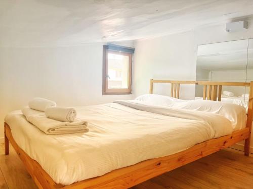 Elle comprend un grand lit avec des draps blancs et des serviettes. dans l'établissement Calme et proche metro, à Villejuif