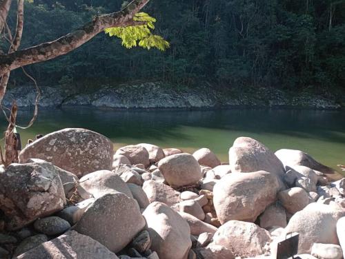 a pile of rocks next to a body of water at Chalé no Sana - Equilíbrio e Descanso in Sana