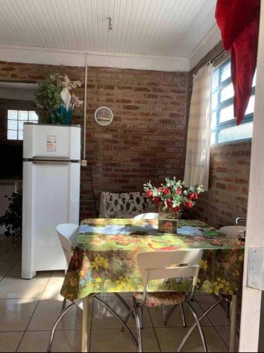 a kitchen with a table and a refrigerator at Hospedagem da Dona Carla in Canela