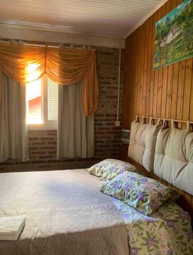 a bedroom with a bed and a window at Hospedagem da Dona Carla in Canela
