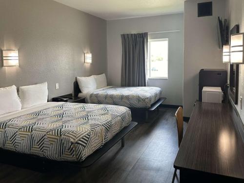 a hotel room with two beds and a table at Motel 6-Mission, TX in Mission