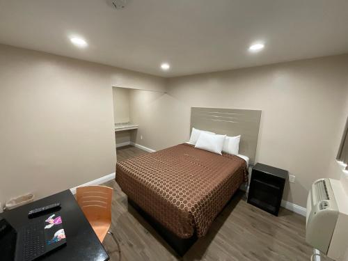 a bedroom with a bed and a desk and a phone at State Motel in South Gate