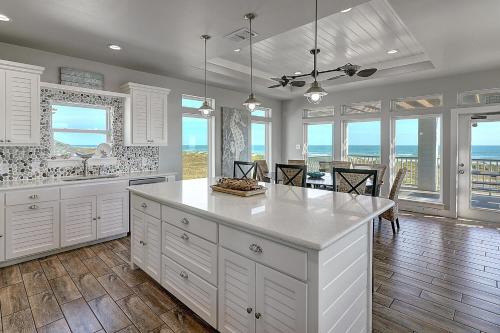 a kitchen with white cabinets and views of the ocean at The Pearl of Port A GW108 in Port Aransas