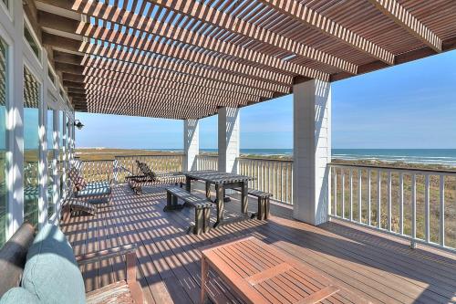 a deck with a picnic table and chairs on the beach at The Pearl of Port A GW108 in Port Aransas