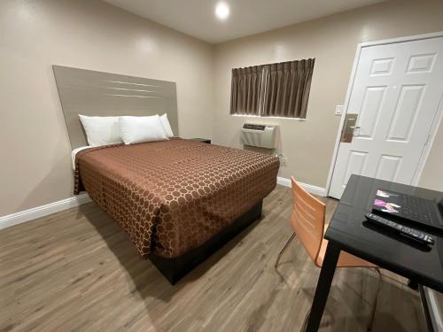 a small room with a bed and a desk and a computer at State Motel in South Gate