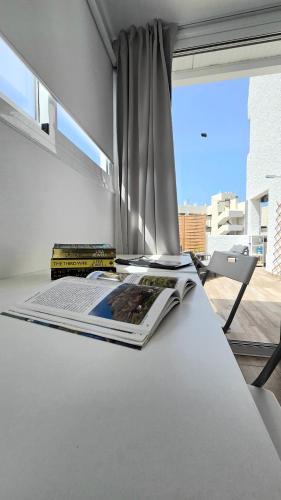 a table with a book on it next to a window at Ocean View Luxury Las Americas in Playa de las Americas