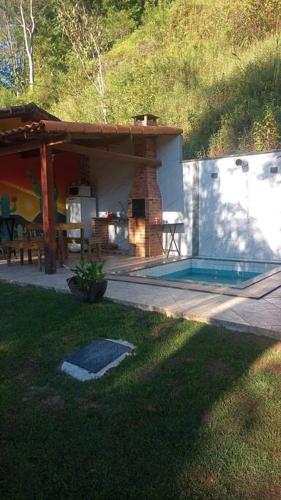 a house with a patio and a swimming pool at Chalé Romântico no Sana - Aconchego e Conforto in Sana