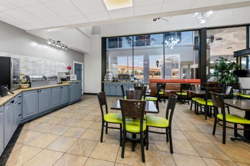 a restaurant with tables and chairs and a kitchen at SureStay Plus Hotel by Best Western Lubbock Medical Center in Lubbock