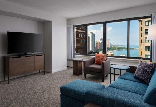 a living room with a blue couch and a large window at Sonesta ES Suites Chicago Downtown Magnificent Mile Medical in Chicago