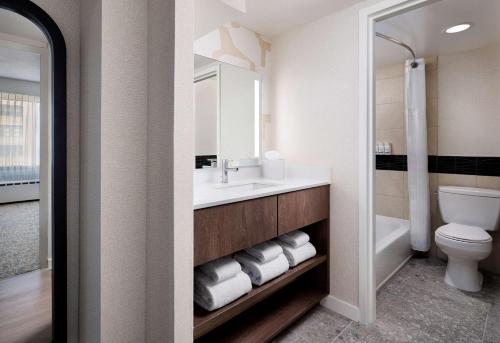 a bathroom with a sink and a toilet and a mirror at Sonesta ES Suites Chicago Downtown Magnificent Mile Medical in Chicago