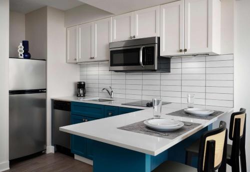 a kitchen with blue cabinets and a sink and a microwave at Sonesta ES Suites Chicago Downtown Magnificent Mile Medical in Chicago