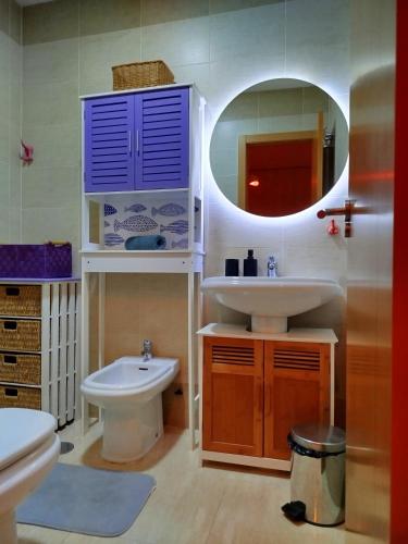 a bathroom with a sink and a toilet and a mirror at Terraza acogedora , Piscina , Parking, Airé Acondicionado in El Campello