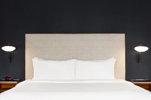 a bedroom with a white bed with two lights at Courtyard Houston Sugar Land/Stafford in Stafford
