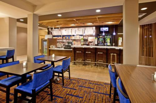a restaurant with tables and chairs and a bar at Courtyard Houston Sugar Land/Stafford in Stafford