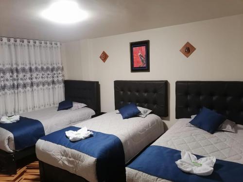 Ένα ή περισσότερα κρεβάτια σε δωμάτιο στο Hostal LUNA DE SAN ANTONIO PUNO