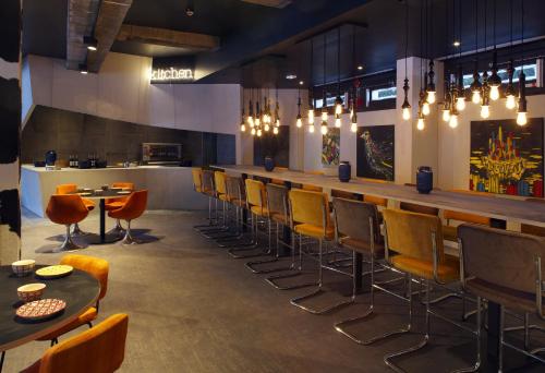 a restaurant with a bar with chairs and tables at Totem, Friendly Hotel & Spa in Flaine