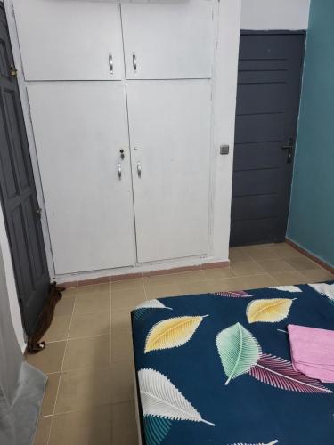 Zimmer mit weißen Schränken und einem Bett. in der Unterkunft Résidence Bon Séjour in Abidjan
