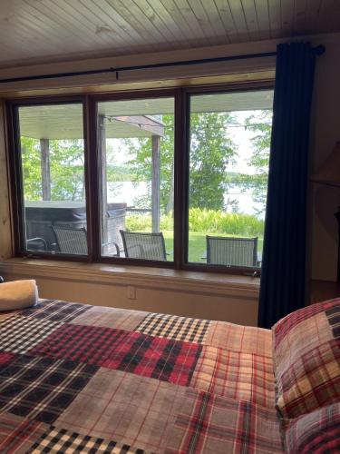 a bedroom with a bed and a window with chairs at Chalet spa rivière saint Maurice in Grandes-Piles
