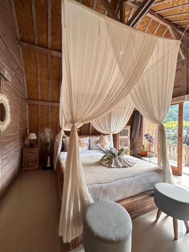 a bedroom with a bed with mosquito netting at Pondok Bali Volcano in Kubupenlokan