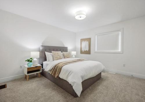 a bedroom with a large bed with white walls at Luxurious and Beautiful, Barrie in Barrie