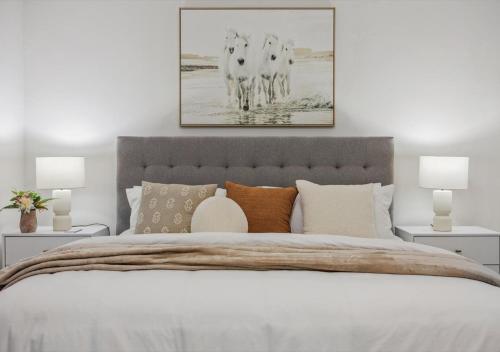 a bedroom with a large bed with two pictures on the wall at Luxurious and Beautiful, Barrie in Barrie