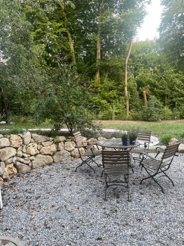 シュタルンベルクにあるWohnung mit Terrasse am Waldrandの砂利のパティオ(テーブル、椅子付)