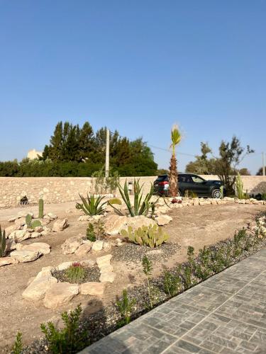 a garden with rocks and plants in a parking lot at Villa Karama Essaouira Getaway in Bou Mkila
