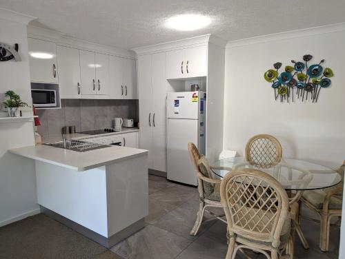 a kitchen with a table and a white refrigerator at Bay Lodge Apartments in Gold Coast