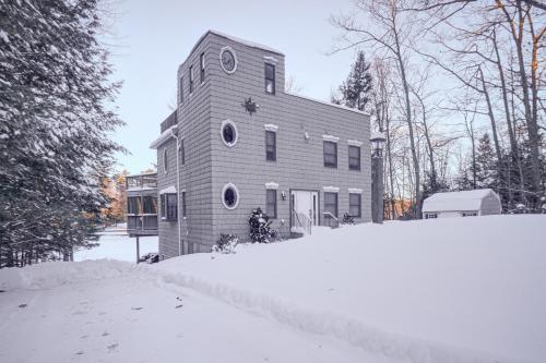 a house with a tower in the snow at 4-Season Home Fireplace and Fire Pit in Barnstead in Barnstead