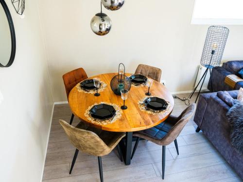 a wooden dining room table with chairs and a couch at Brabants Weelde in Molenschot