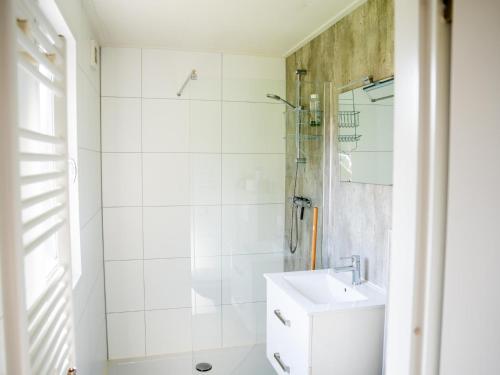 a white bathroom with a shower and a sink at Brabants Weelde in Molenschot