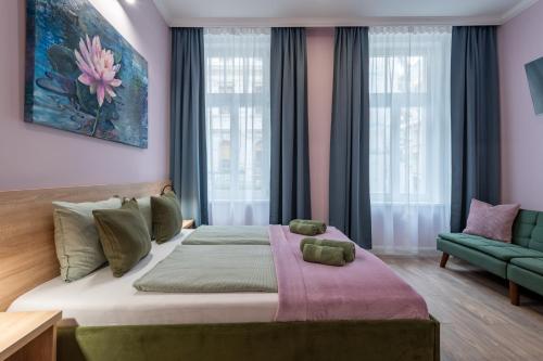 a bedroom with a large bed and a green couch at Budapest Holidays Downtown in Budapest