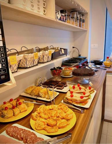 a buffet with several plates of food on a counter at Pousada Villa Vantino in Penha