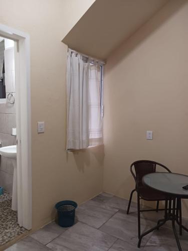 a room with a table and a sink and a window at POSADA del MAR in Puerto Escondido