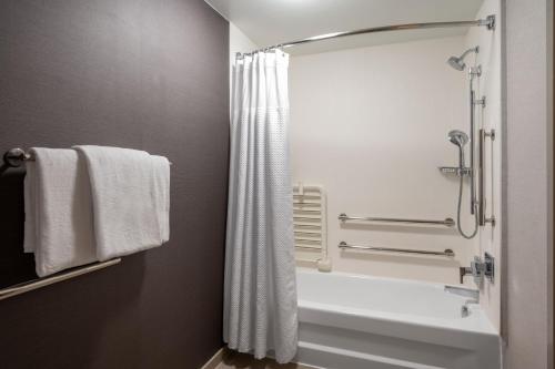 a bathroom with a tub and a shower with a shower curtain at Courtyard Columbus Airport in Columbus