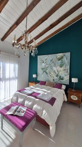 a bedroom with a large bed and a chandelier at Cabañas Terruños de Pilar in Malargüe