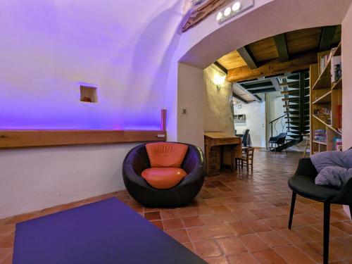 a living room with a chair and a table at Gîte d'exception avec spa, jardin paysagé et équipements haut de gamme à Blanlhac - FR-1-582-201 in Rosières