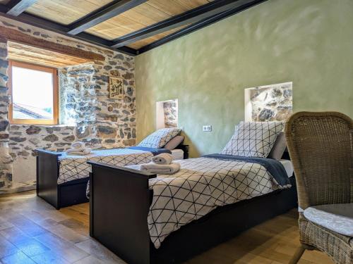 two beds in a room with a stone wall at Gîte d'exception avec spa, jardin paysagé et équipements haut de gamme à Blanlhac - FR-1-582-201 in Rosières