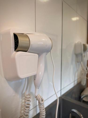 a white phone is hanging on a wall at Pousada Villa Vantino in Penha