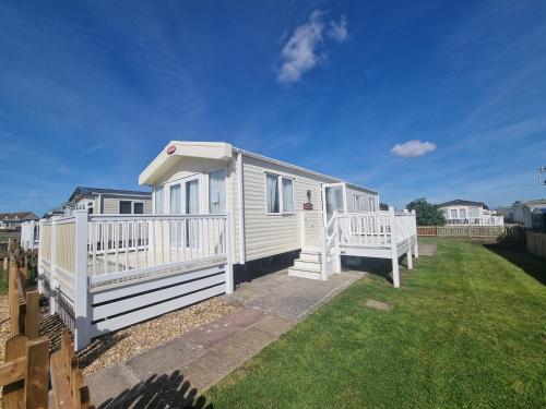 a white tiny house in a yard with a fence at Beautiful accomodation 714 Unity Beach Brean Sleeps 4 Pet friendly pets stay free in Brean