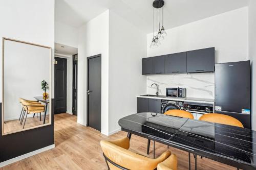une cuisine avec une table et des chaises dans une pièce dans l'établissement Appartement Neuf Lyon - Haut de gamme, à Lyon