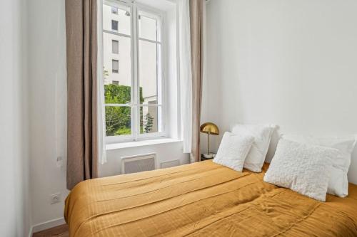 un lit dans une chambre blanche avec une fenêtre dans l'établissement Appartement Neuf Lyon - Haut de gamme, à Lyon