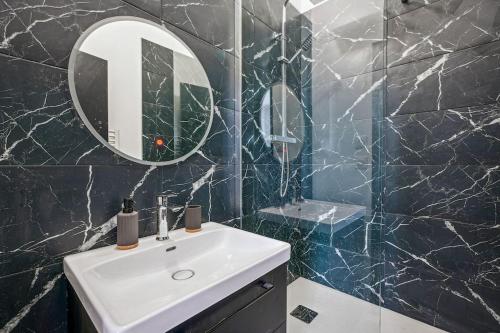 une salle de bain avec un lavabo et un miroir dans l'établissement Appartement Neuf Lyon - Haut de gamme, à Lyon