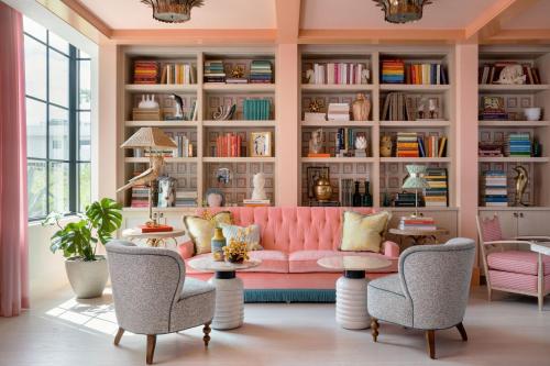 a living room with a pink couch and chairs at The Goodtime Hotel, Miami Beach a Tribute Portfolio Hotel in Miami Beach