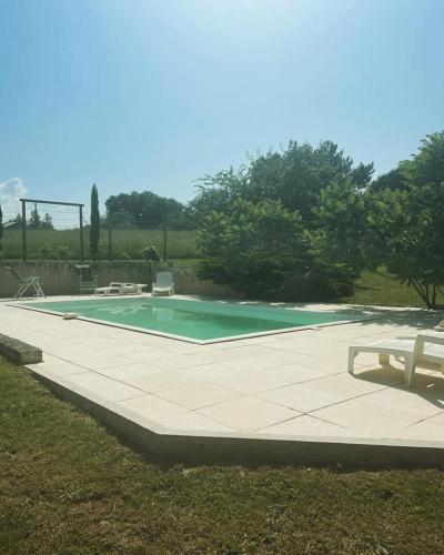 - une piscine entourée d'une table et d'un banc dans l'établissement Gîte la Maison du Queyran, à Villefranche-du-Queyran