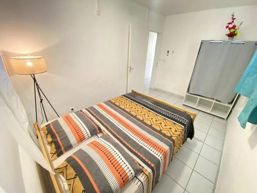 a bedroom with a bed in a room with a lamp at Appartement T3 - Vue mer & proche des plages in Boucan