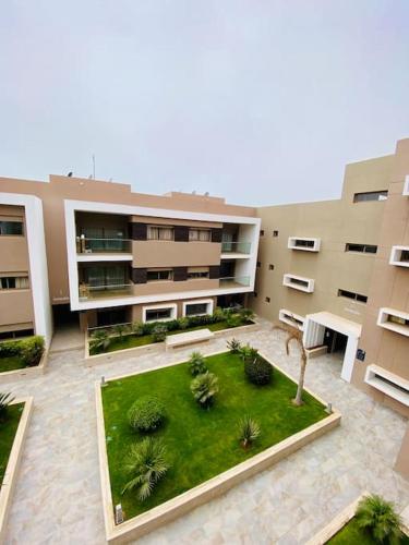 an apartment building with a lawn in front of it at surf nour house in Tamraght Ouzdar