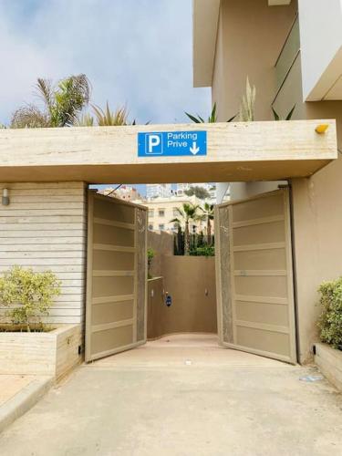a garage with a parking sign on top of it at surf nour house in Tamraght Ouzdar